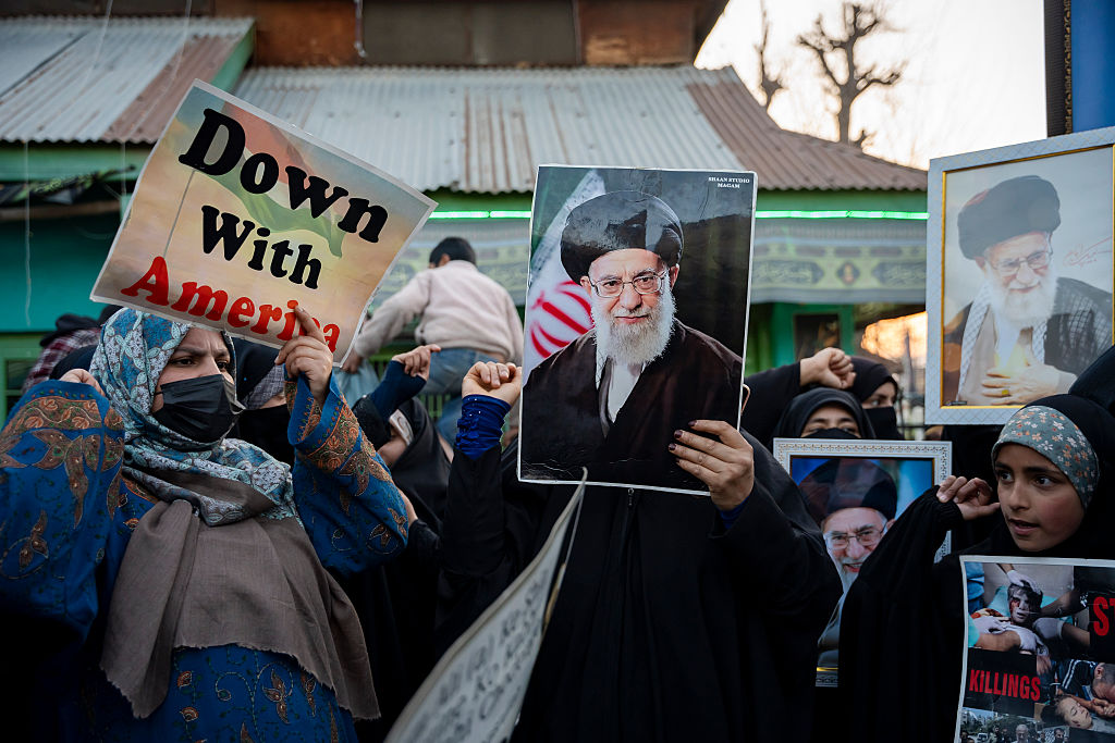 Protesters hold photographs of Ayatollah Ali Khamenei and a